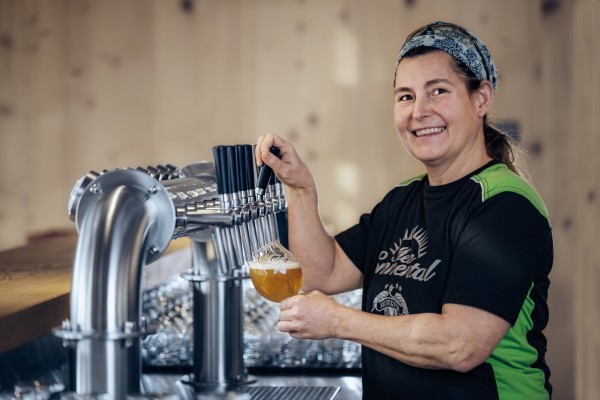 Businessfotografie zeigt Bierbrauerin beim Ausschank ihres selbstgebrauten Bieres.