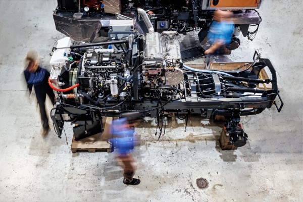 Businessfotografie zeigt mehrerer Mitarbeitern bei der Montage eines Fahrgestelles zu einem Schneeräumungsfahrzeuges.